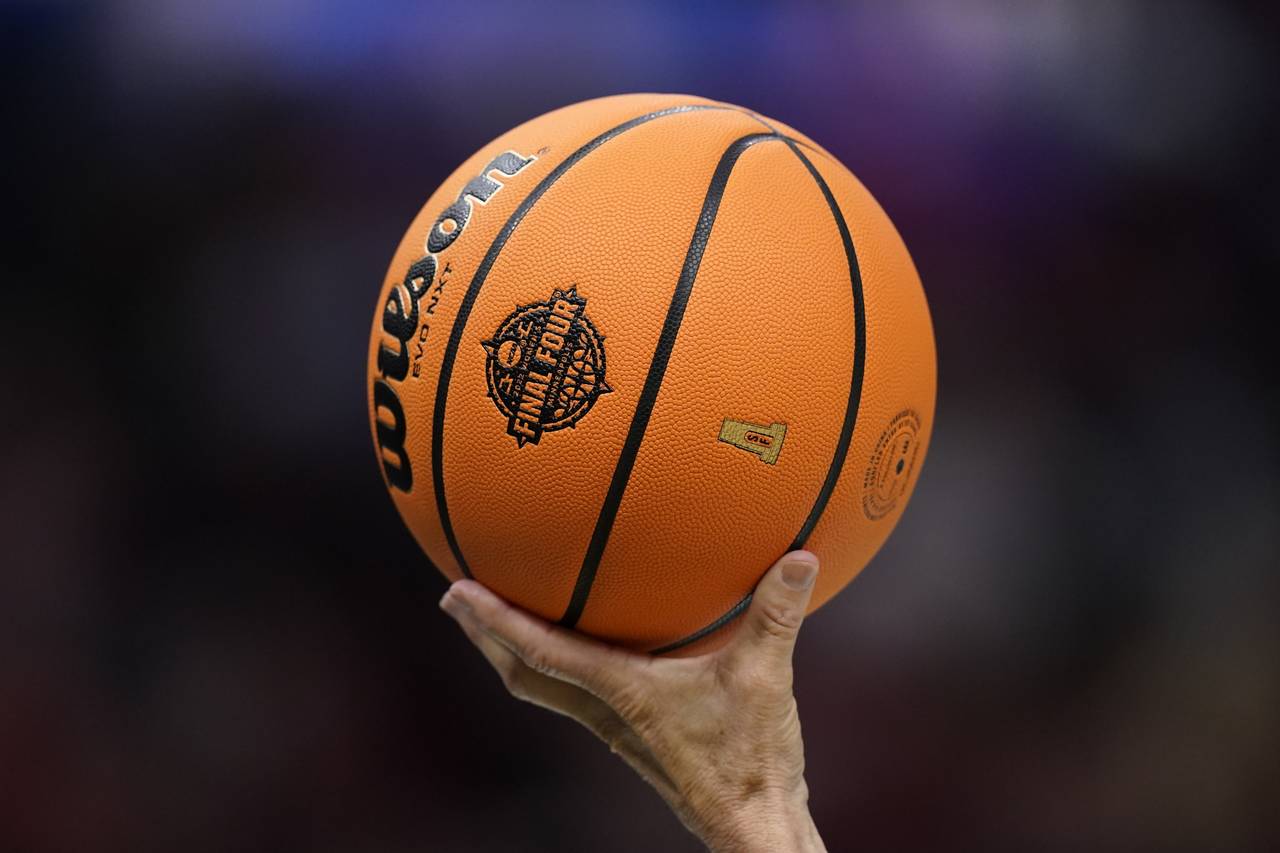 A referee holds up a ball during the second half of a college basketball game in the semifinal roun...