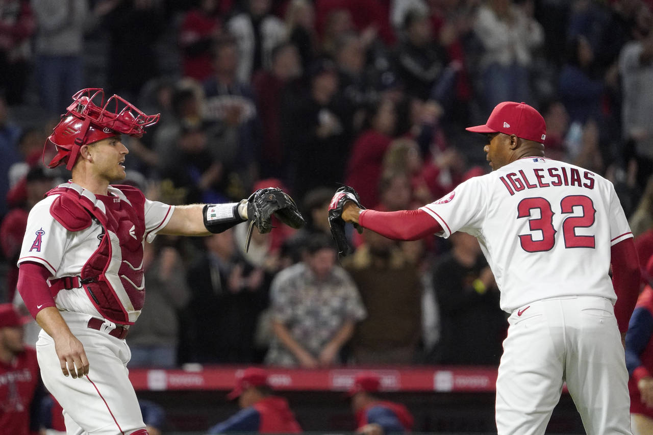 Los Angeles Angels catcher Max Stassi, left, and relief pitcher Raisel Iglesias congratulate each o...