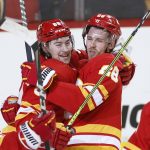 Calgary Flames left wing Andrew Mangiapane (88) celebrates his goal against the Seattle Kraken with Elias Lindholm (28) during the third period of an NHL hockey game Tuesday, April 12, 2022, in Calgary, Alberta. (Larry MacDougal/The Canadian Press via AP)