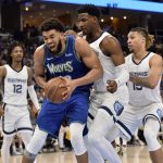 
              Minnesota Timberwolves center Karl-Anthony Towns handles the ball against Memphis Grizzlies forward Jaren Jackson Jr., center, and center Brandon Clarke (15) in the second half of Game 1 of a first-round NBA basketball playoff series Saturday, April 16, 2022, in Memphis, Tenn. (AP Photo/Brandon Dill)
            