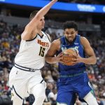 
              Minnesota Timberwolves center Karl-Anthony Towns, right, drives the lane as Denver Nuggets center Nikola Jokic defends in the first half of an NBA basketball game Friday, April 1, 2022, in Denver. (AP Photo/David Zalubowski)
            