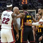 
              Atlanta Hawks forward De'Andre Hunter (12) stands between Miami Heat forward Jimmy Butler (22) and guard Trae Young (11) after both were called for foul during the first half of Game 1 of an NBA basketball first-round playoff series, Sunday, April 17, 2022, in Miami. (AP Photo/Lynne Sladky)
            