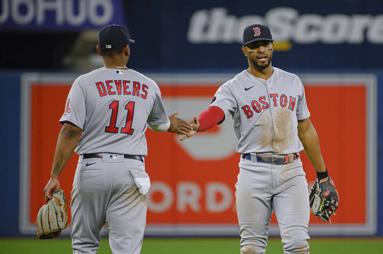 Boston Red Sox shortstop Xander Bogaerts, right, and third baseman Rafael Devers (11) celebrate dur...
