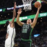 
              Boston Celtics forward Grant Williams (12) drives toward the basket past Brooklyn Nets guard Kyrie Irving in the first half of Game 1 of an NBA basketball first-round Eastern Conference playoff series, Sunday, April 17, 2022, in Boston. (AP Photo/Steven Senne)
            