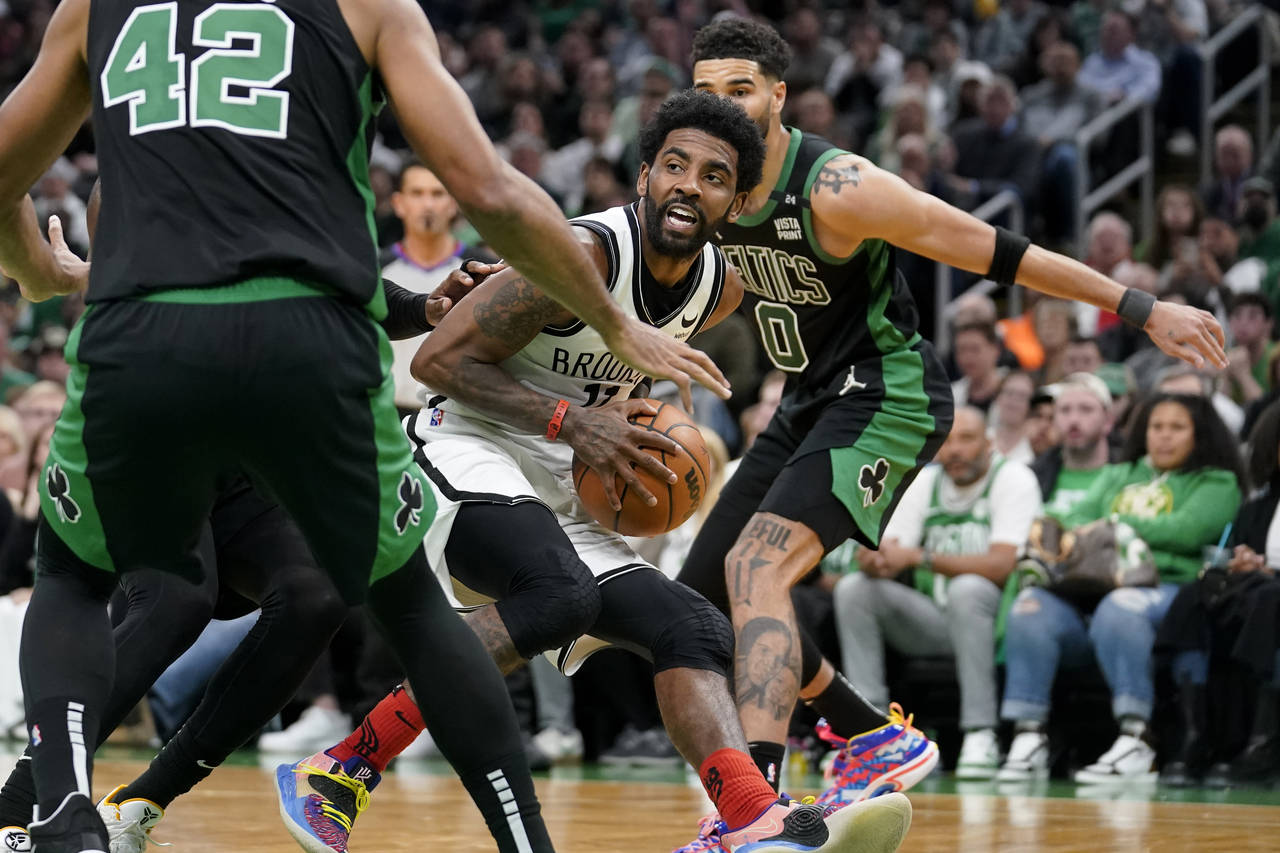 Brooklyn Nets guard Kyrie Irving, center, looks for an opening around Boston Celtics center Al Horf...