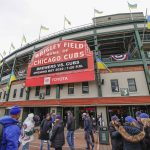 
              Ukrainian flags are seen outside Wrigley Field as fans arrive for the Chicago Cubs home-opener baseball game against the Milwaukee Brewers, Thursday, April 7, 2022, in Chicago. (AP Photo/Kamil Krzaczynski)
            