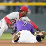 
              Philadelphia Phillies second baseman Jean Segura, back, fields the throw as Colorado Rockies' Brendan Rodgers slides safely into second base with a double in the eighth inning of a baseball game Monday, April 18, 2022, in Denver. (AP Photo/David Zalubowski)
            