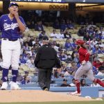 
              Los Angeles Angels' Brandon Marsh, right, rounds third after hitting a solo home run as Los Angeles Dodgers starting pitcher Julio Urias stands on the mound during the third inning of a spring training baseball game Monday, April 4, 2022, in Los Angeles. (AP Photo/Mark J. Terrill)
            