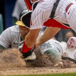 
              Oakland Athletics' Cristian Pache (20) is safe at home before Philadelphia Phillies catcher J.T. Realmuto (10) can make the tag on a two run RBI by Tony Kemp during the ninth inning of a baseball game, Sunday, April 10, 2022, in Philadelphia. (AP Photo/Laurence Kesterson)
            