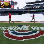 
              Members of the grounds crew roll up the tarp before baseball workouts at Nationals Park, Wednesday, April 6, 2022, in Washington. The Washington Nationals and the New York Mets are scheduled to play on opening day, Thursday. (AP Photo/Alex Brandon)
            