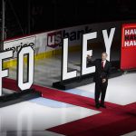 
              Pat Foley waves the crowd as he walks on the ice before an NHL hockey game between the San Jose Sharks and the Chicago Blackhawks in Chicago, Thursday, April 14, 2022. Foley rings down the curtain on his 39-year run as the voice of the Blackhawks, Thursday night when San Jose takes the ice at the United Center. (AP Photo/Nam Y. Huh)
            