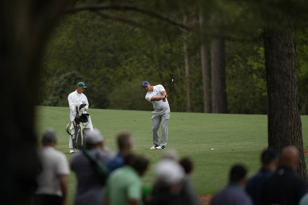 Bryson DeChambeau hits from the fairway on the 11th hole during a practice round for the Masters go...