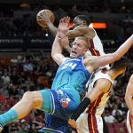 
              Miami Heat center Bam Adebayo, top, goes for the ball against Charlotte Hornets center Mason Plumlee (24) during the first half of an NBA basketball game Tuesday, April 5, 2022, in Miami. (AP Photo/Lynne Sladky)
            