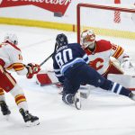 
              Calgary Flames goaltender Dan Vladar (80) saves the shot from Winnipeg Jets' Pierre-Luc Dubois (80) as Nikita Zadorov (16) defends during the second period of an NHL hockey game Friday, April 29, 2022 in Winnipeg, Manitoba. (John Woods/The Canadian Press via AP)
            