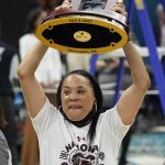 
              South Carolina head coach Dawn Staley holds up the trophy after a college basketball game in the final round of the Women's Final Four NCAA tournament against UConn Sunday, April 3, 2022, in Minneapolis. South Carolina won 64-49 to win the championship. (AP Photo/Eric Gay)
            