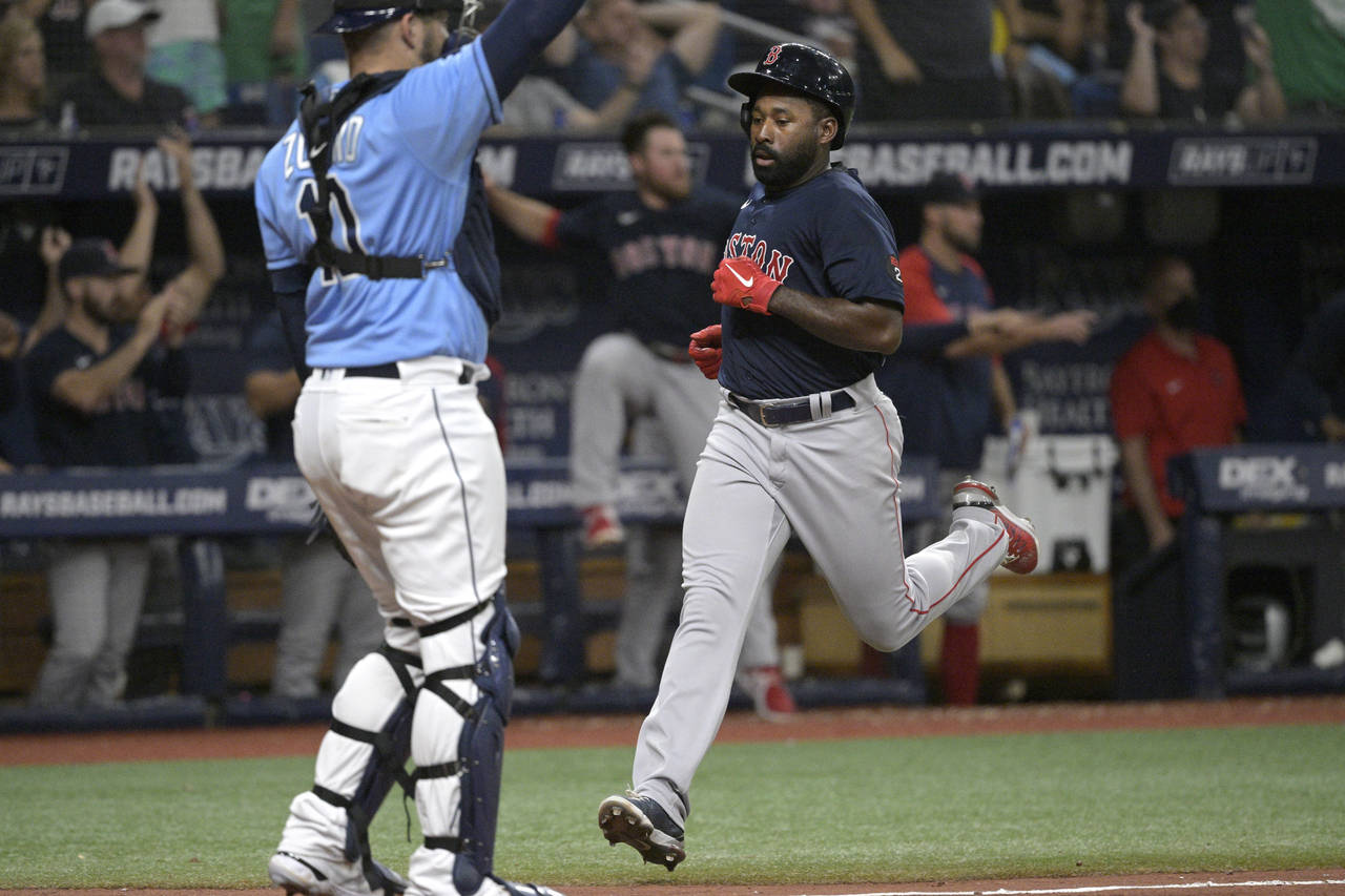 Boston Red Sox's Jackie Bradley Jr., right, scores past Tampa Bay Rays catcher Mike Zunino (10) dur...