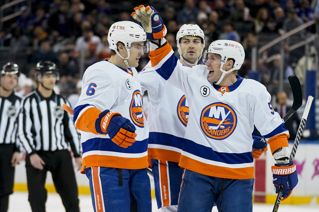 New York Islanders center Casey Cizikas, right, celebrates after scoring on New York Rangers goalte...