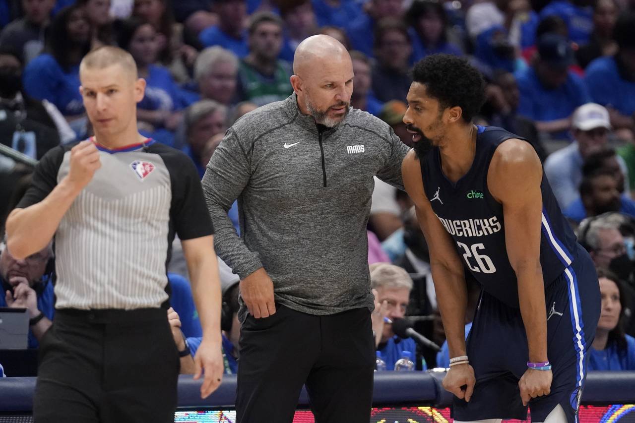 Referee Tyler Ford, left, stands by as Dallas Mavericks head coach Jason Kidd, center, talks with g...