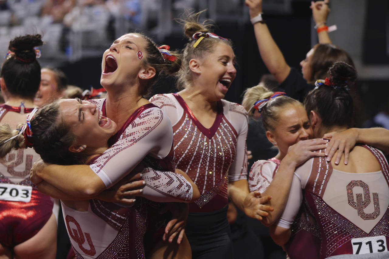 Oklahoma team celebrates their victory together after the NCAA college women's gymnastics champions...
