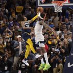 
              Memphis Grizzlies guard Ja Morant (12) takes the game winning shot against Minnesota Timberwolves forward Jarred Vanderbilt (8) in the second half during Game 5 of a first-round NBA basketball playoff series Tuesday, April 26, 2022, in Memphis, Tenn. (AP Photo/Brandon Dill)
            
