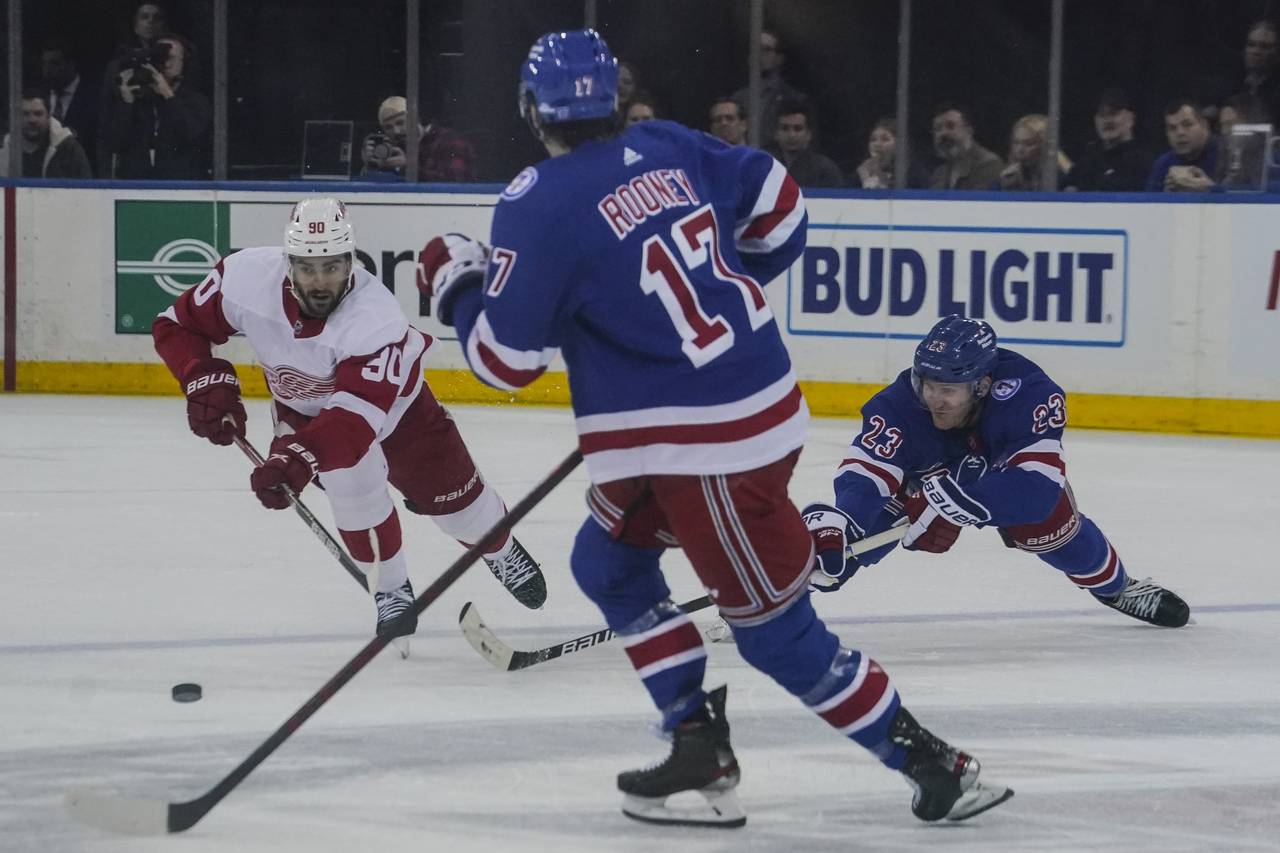 Detroit Red Wings center Joe Veleno (90) goes after loose puck against New York Rangers center Kevi...