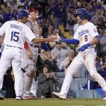
              Los Angeles Dodgers' Austin Barnes, left, congratulates Trea Turner, right, after hitting a two-run home run as Cincinnati Reds catcher Tyler Stephenson watches during the sixth inning of a baseball game Saturday, April 16, 2022, in Los Angeles. (AP Photo/Mark J. Terrill)
            