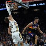 
              New Orleans Pelicans center Jaxson Hayes (10) dunks as Phoenix Suns guard Devin Booker (1) defends during the second half of Game 2 of an NBA basketball first-round playoff series, Tuesday, April 19, 2022, in Phoenix. (AP Photo/Matt York)
            