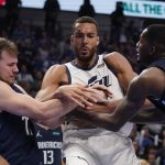 
              Utah Jazz center Rudy Gobert, center, struggle with Dallas Mavericks guard Luka Doncic, left, and forward Dorian Finney-Smith, right for control of the ball during the second half of Game 5 of an NBA basketball first-round playoff series, Monday, April 25, 2022, in Dallas. (AP Photo/Tony Gutierrez)
            