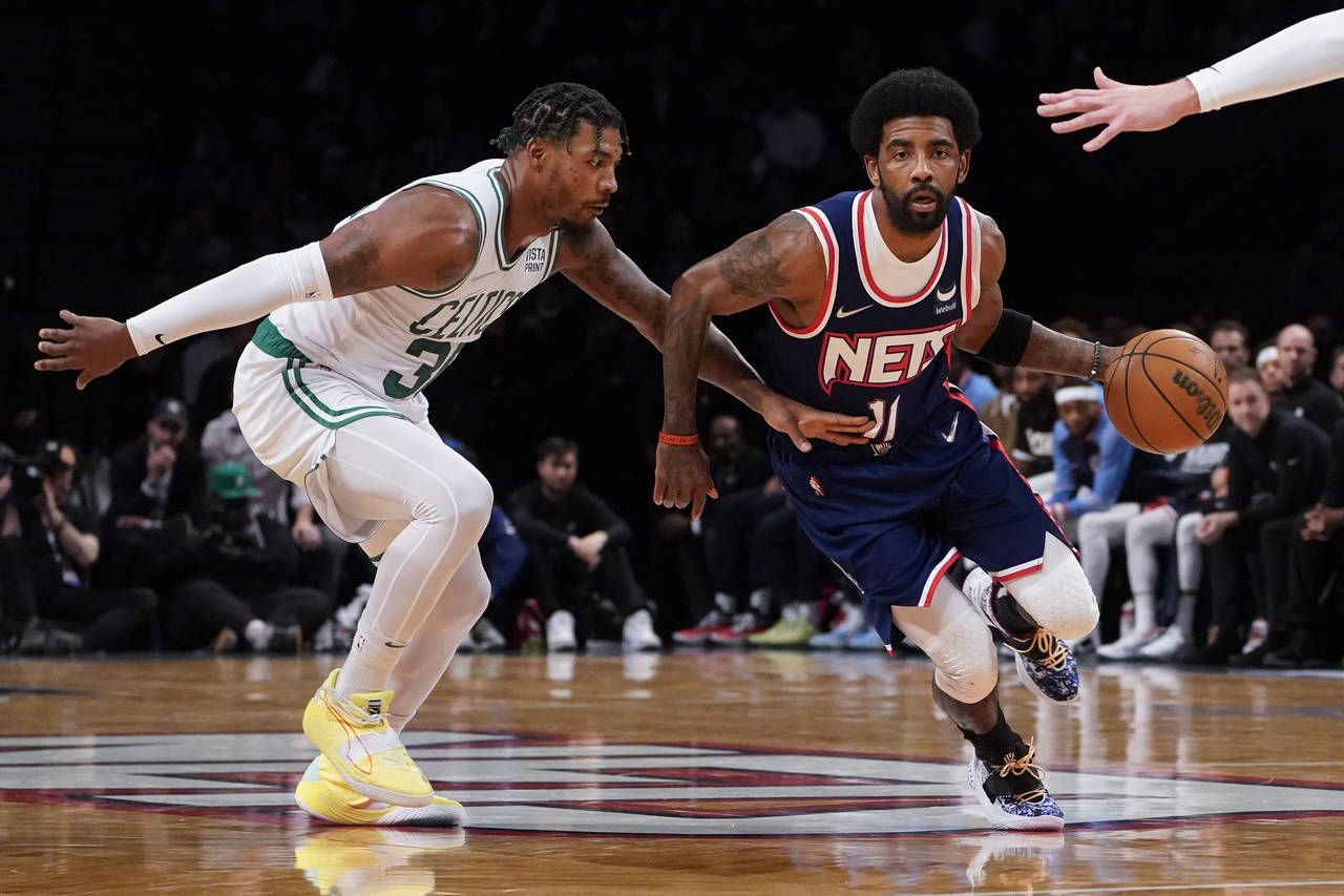 Brooklyn Nets guard Kyrie Irving (11) drives past Boston Celtics guard Marcus Smart, left, during t...