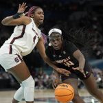 
              Louisville's Olivia Cochran tries to drive past South Carolina's Aliyah Boston during the first half of a college basketball game in the semifinal round of the Women's Final Four NCAA tournament Friday, April 1, 2022, in Minneapolis. (AP Photo/Eric Gay)
            