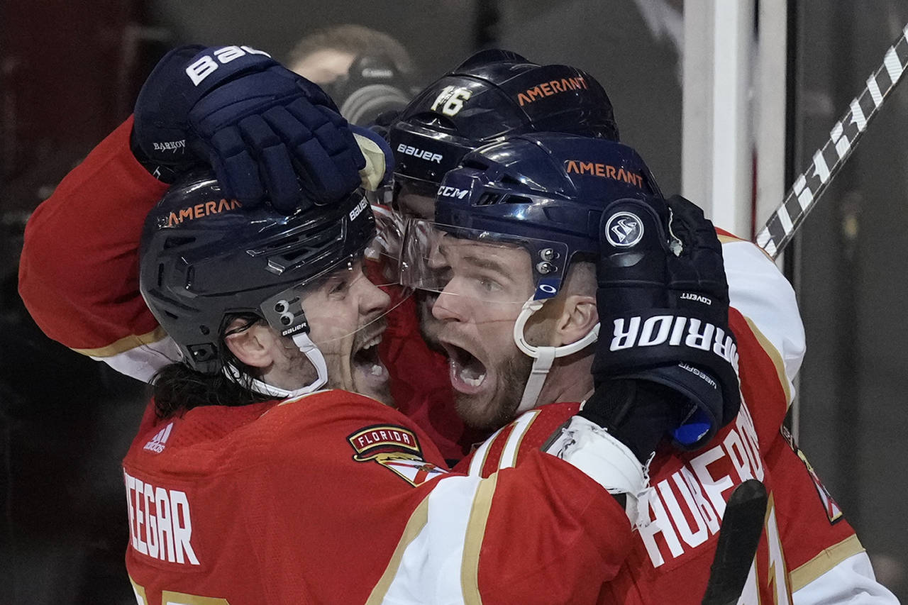 Florida Panthers left wing Jonathan Huberdeau, right, celebrates with teammates after scoring in ov...