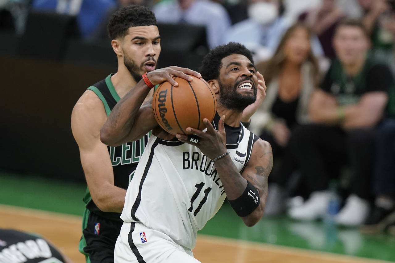 Brooklyn Nets guard Kyrie Irving (11) drives toward the basket as Boston Celtics forward Jayson Tat...
