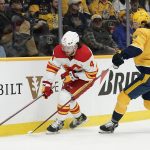 
              Calgary Flames' Rasmus Andersson (4) is defended by Nashville Predators' Cody Glass (8) in the second period of an NHL hockey game Tuesday, April 19, 2022, in Nashville, Tenn. (AP Photo/Mark Humphrey)
            