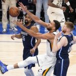 
              Utah Jazz center Rudy Gobert (27) reaches out to collect a rebound between Dallas Mavericks' Spencer Dinwiddie-, left, and Davis Bertans, right, in the first half of Game 1 of an NBA basketball first-round playoff series, Saturday, April 16, 2022, in Dallas. (AP Photo/Tony Gutierrez)
            