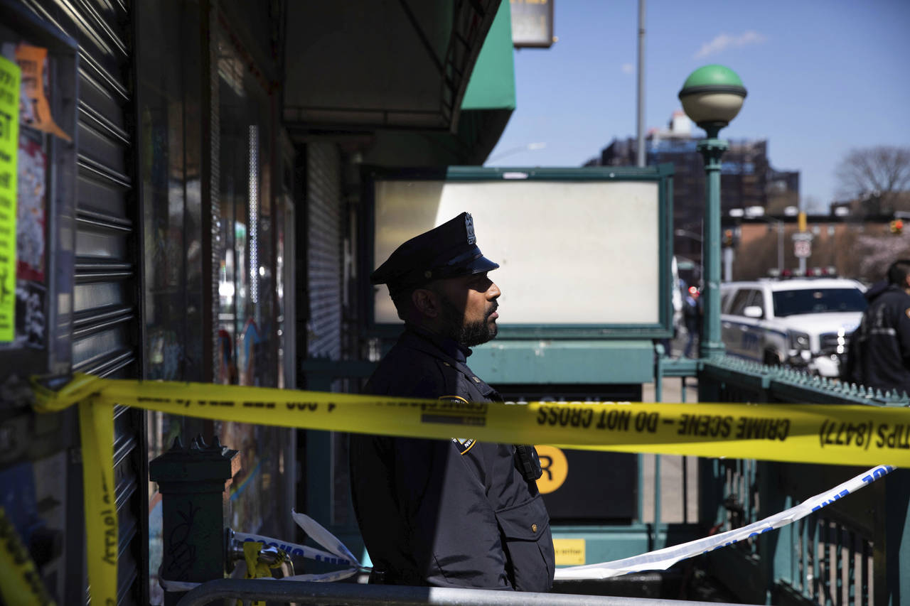 A police officer stands watch at the entrance of 36th Street Station after multiple people were sho...