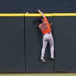 
              Houston Astros right fielder Chas McCormick (20) slams against the wall while attempting to reach a solo home run hit by Texas Rangers' Corey Seager in the seventh inning of a baseball game, Thursday, April 28, 2022, in Arlington, Texas. (AP Photo/Tony Gutierrez)
            