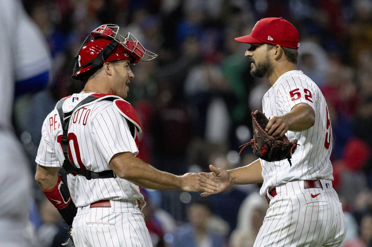 Philadelphia Phillies closing pitcher Brad Hand (52) and catcher J.T. Realmuto (10) celebrate after...