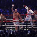 
              Britain's Tyson Fury, center, celebrates after beating Britain's Dillian Whyte during their WBC heavyweight title boxing fight at Wembley Stadium in London, Saturday, April 23, 2022. (AP Photo/Ian Walton)
            