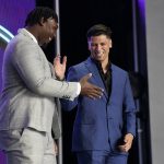 
              Mississippi quarterback Matt Corral, right, shakes hands with Mississippi State offensive lineman Charles Cross during the first round of the NFL football draft Thursday, April 28, 2022, in Las Vegas. (AP Photo/John Locher)
            