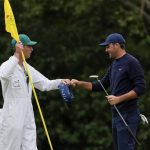 
              Scottie Scheffler pumps fist with his caddie Ted Scott after putting on the 11th green during the second round at the Masters golf tournament on Friday, April 8, 2022, in Augusta, Ga. (AP Photo/Matt Slocum)
            
