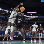 
              South Carolina's Aliyah Boston and Louisville's Olivia Cochran go after a loose ball during the first half of a college basketball game in the semifinal round of the Women's Final Four NCAA tournament Friday, April 1, 2022, in Minneapolis. (AP Photo/Eric Gay)
            