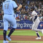 
              Houston Astros' Yordan Alvarez runs the bases after hitting a solo home run off Toronto Blue Jays' starting pitcher Jose Barrios, left, in the fourth inning of a baseball game in Toronto, Saturday, April 30, 2022. (Jon Blacker/The Canadian Press via AP)
            