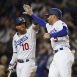 
              Los Angeles Dodgers designated hitter Justin Turner (10) high-fives Freddie Freeman (5) after Freeman scored off of a single hit by Trea Turner during the eighth inning of a baseball game against the Cincinnati Reds in Los Angeles, Thursday, April 14, 2022. (AP Photo/Ashley Landis)
            