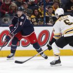 
              Columbus Blue Jackets defenseman Zach Werenski, left, passes the puck in front of Boston Bruins defenseman Mike Reilly during the second period of an NHL hockey game in Columbus, Ohio, Monday, April 4, 2022. (AP Photo/Paul Vernon)
            