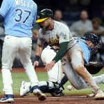 
              Oakland Athletics' Seth Brown (15) scores as Tampa Bay Rays catcher Mike Zunino (10) can't hang onto the ball after a single by Stephen Piscotty during the sixth inning of a baseball game Tuesday, April 12, 2022, in St. Petersburg, Fla. (AP Photo/Chris O'Meara)
            
