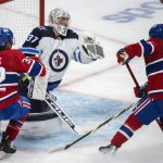 
              Montreal Canadiens' Rem Pitllck (32) and teammate Cole Caufield move in on Winnipeg Jets Connor Hellebuyck during the first period of an NHL hockey game in Montreal, Monday, April 11, 2022. (Graham Hughes/The Canadian Press via AP)
            