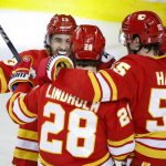 
              Calgary Flames center Elias Lindholm, center, celebrates his goal against the Vancouver Canucks with left wing Johnny Gaudreau, left, and defenseman Noah Hanifin during the second period of an NHL hockey game Saturday, April 23, 2022, in Calgary, Alberta. (Jeff McIntosh/The Canadian Press via AP)
            