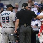 
              Umpire Ted Barrett stands between Atlanta Braves' Marcell Ozuna (20) and Miami Marlins first baseman Jesus Aguilar (99) after Ozuna was hit by a pitch during the first inning of a baseball game Saturday, April 23, 2022, in Atlanta. (AP Photo/John Bazemore)
            