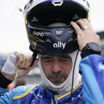 
              Jimmie Johnson puts on his helmet during IndyCar auto racing testing at Indianapolis Motor Speedway, Wednesday, April 20, 2022, in Indianapolis. (AP Photo/Darron Cummings)
            