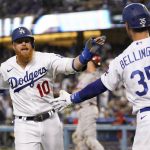 
              Los Angeles Dodgers designated hitter Justin Turner (10) celebrates with Cody Bellinger (35) after Turner scored off of a single hit by Will Smith during the first inning of a baseball game against the Cincinnati Reds in Los Angeles, Thursday, April 14, 2022. (AP Photo/Ashley Landis)
            